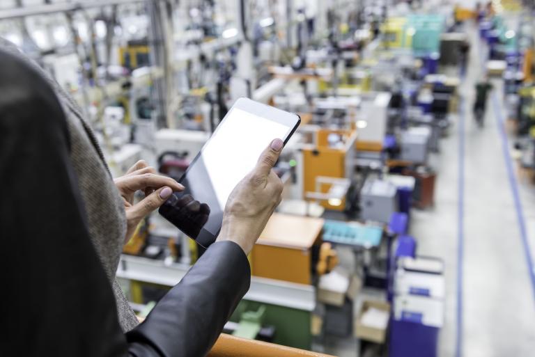 Ondernemer in fabriekshal met tablet